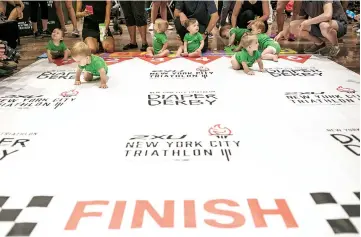  ?? — AFP photo ?? Babies ‘warm up’ before racing in the NYC Triathlon’s annual Diaper Derby, in New York City.