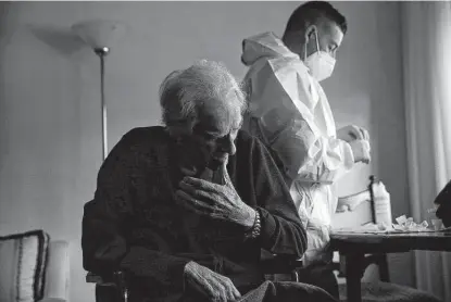  ?? Cecilia Fabiano / Associated Press ?? A medical staff member prepares to administer a dose of the Pfizer vaccine to 96-year-old Francesco Conte at his home in Rome on Wednesday. So far, just under 10 percent of Italy’s population has received at least one dose of a COVID vaccine.