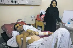  ?? ADEL HANA ASSOCIATED PRESS ?? Marwan Shtewi, 32, recovers Wednesday at the surgery ward of Shifa hospital in Gaza City with his mother, Fatma. Shtewi was shot in his hand and abdomen by Israeli troops during a border protest east of Gaza City on Monday.