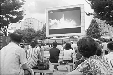  ??  ?? This file photo shows people watching as coverage of an ICBM missile test is displayed on a screen in a public square in Pyongyang. — AFP photo