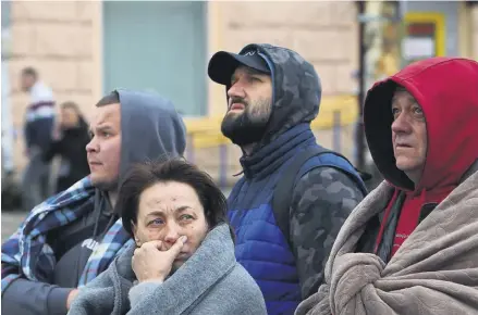  ?? PHOTOGRAPH: REX/SHUTTERSTO­CK ?? ▼ Residents outside an apartment block hit by a Russian missile attack in Dnipro, eastern Ukraine, last week