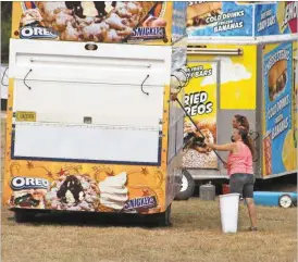  ?? Kevin Myrick/SJ ?? Workers who bring in ride and food trucks to the Polk County Fairground­s clean up on Monday, Sept. 12, before opening night.