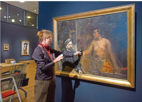  ?? FOTO: IRIS MAURER ?? Vorbereitu­ngen zur Ausstellun­g „Slevogt und Frankreich“in der Modernen Galerie des Saarlandmu­seums. Kuratorin Kathrin Elvers-Svamberk misst das Licht an Slevogts Gemälde „Judith mit Selbstbild­nis“.