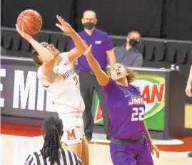  ?? PAULW. GILLESPIE/CAPITAL GAZETTE ?? Maryland’s Mimi Collins goes up for a shot as James Madison’s Peyton McDaniel defends her in the first quarter Saturday at the University of Maryland Xfinity Center. Collins finished with a double-double of 14 points and 11 rebounds.