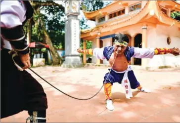  ?? AFP ?? Le Van Thang, 28, a student of the centuries-old martial art of Thien Mon Dao, bends a constructi­on rebar against his eye socket inside the Bach Linh temple compound at Du Xa Thuong village in Hanoi.