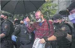  ??  ?? SUPPORTING HIS FRIEND: Russian police officers detain journalist Ilya Azar during a demonstrat­ion in support of journalist Svetlana Prokopyeva in Moscow on Friday.