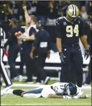  ?? Associated Press ?? DEFEATED — Philadelph­ia Eagles wide receiver Alshon Jeffery (17) lies on the turf in front of New Orleans Saints defensive end Cameron Jordan (94) after the Saints intercepte­d a pass in the second half of an NFL divisional playoff football game in New Orleans on Sunday. The Saints won 20-14.