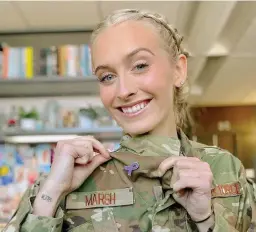  ?? ?? Air Force 2nd Lt. Madison Marsh proudly shows off her purple ribbon lapel pin symbolizin­g pancreatic cancer awareness, a disease her mother died from in 2018.