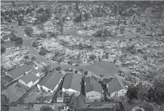  ?? JOSH HANER/THE NEW YORK TIMES ?? ABOVE: An aerial view Wednesday of a handful of homes that escaped destructio­n in the Coffey Park neighborho­od of Santa Rosa, Calif. The wildfires in Northern California, which have destroyed at least 3,500 homes and businesses, are among the deadliest...