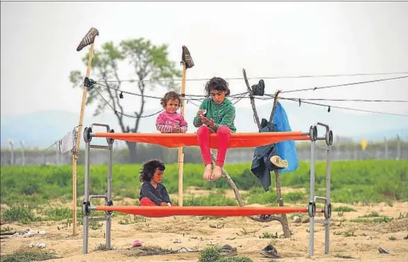  ?? DANIEL MIHAILESCU / AFP ?? Niños refugiados juegan en el campamento de Idomeni, en la frontera entre Grecia y Macedonia, donde permanecen unas 10.000 personas