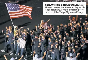  ??  ?? RED, WHITE & BLUE WAVE: Eddy Alvarez carries the American flag as he leads Team USA into the opening ceremonies at the Tokyo Olympics Friday.
