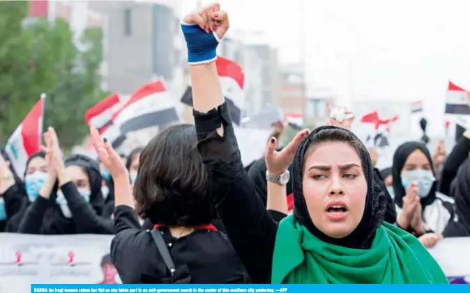  ??  ?? BASRA: An Iraqi woman raises her fist as she takes part in an anti-government march in the center of this southern city yesterday. —AFP