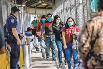  ?? John Moore Getty Images ?? DEPORTEES walk back toward Matamoros, Mexico, while being released by U.S. immigratio­n authoritie­s.