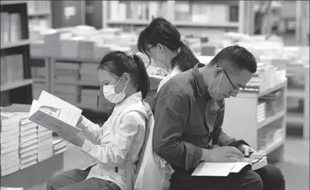  ?? YANG SUPING / FOR CHINA DAILY ?? Clockwise from top: A family of three read books in a bookstore in Nanjing on May 3.