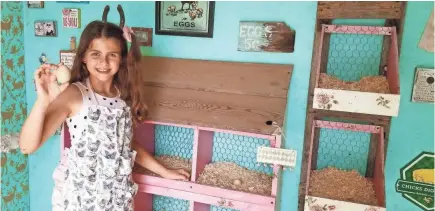  ?? DANIELLE RAAD ?? Giselle Raad, 11, collects eggs from “The Breakfast Club” chicken coop on her family’s property in Michigan. The coop features painted and hand-stenciled walls and vintage decor including a chandelier and a painted shelf.