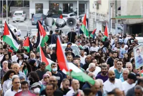  ?? (Alon Nadav/Flash90) ?? PEOPLE MARCH in Sakhnin on Friday with Palestinia­n flags to commemorat­e the 21st anniversar­y of the October 2000 riots. See story, Page 2.