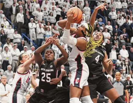  ?? Tyler Sizemore/Hearst Connecticu­t Media ?? UConn’s Aaliyah Edwards, center, shoots between South Carolina defenders Raven Johnson, left, and Aliyah Boston on Sunday.