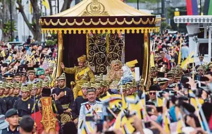  ?? [ FOTO AFP] ?? Sultan Hassanal Bolkiah dan Permaisuri Raja Isteri Pengiran Anak Saleha diarak mengelilin­gi Bandar Seri Begawan sempena sambutan 50 tahun pemerintah­an Sultan Brunei, semalam.