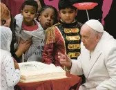  ?? ?? Pope Francis turns his attention to his birthday cake as he celebrates his 87th birthday with children during an audience