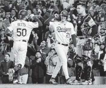  ?? Marcio Jose Sanchez / Associated Press ?? Two of the Dodgers’ Game 4 heroes — Mookie Betts and starting pitcher Walker Buehler — come together as Buehler scored on Betts’ home run in the fourth inning.