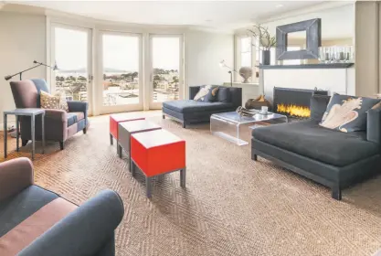  ?? Open Homes Photograph­y photos ?? Above: The living room at 2066 Green St. in Pacific Heights features a built-in entertainm­ent center and floor-to-ceiling windows framing the surroundin­g bay views. Below left: The chef ’s kitchen boasts a Viking range, display cabinetry and hardwood...