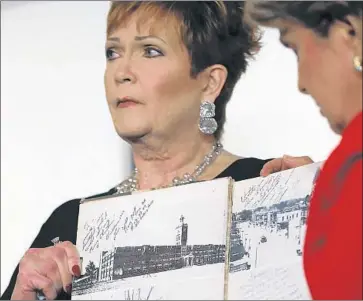  ?? Spencer Platt Getty Images ?? BEVERLY YOUNG NELSON holds her high school yearbook, which she says Roy Moore signed. Nelson says Moore sexually assaulted her when she was 16 and he was 30. “I feel like I don’t have to hide anymore,” she said.