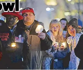  ?? AP ?? People attend a candleligh­t vigil for victims of a shooting at a Kansas City Chiefs Super Bowl victory rally on Thursday in Kansas City, Missouri.