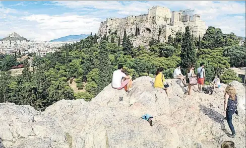  ?? IGNACIO OROVIO ?? Turismo. Los visitantes observan, al fondo, la Acrópolis, máximo
punto de atracción de Atenas