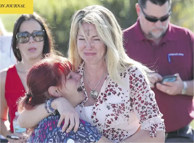  ?? JOEL AUERBACH / THE ASSOCIATED PRESS ?? Distraught parents wait for news after reports of a shooting spree at Marjory Stoneman Douglas High School in Parkland, Fla., on Wednesday.