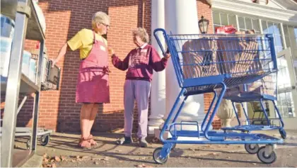  ?? STAFF PHOTO BY MATT HAMILTON ?? Volunteers Lynn Dee Johnson, left, and Gwen Holden chat Wednesday as the Brainerd Community Food Pantry distribute­s food at Brainerd United Methodist Church.