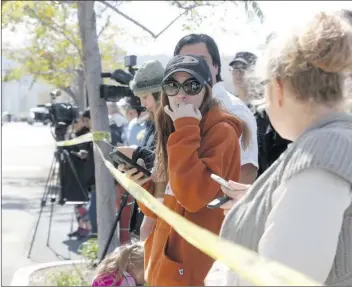  ?? Nikolas Samuels/The Signal ?? Families wait to pick up their kids behind caution tape at SCVi in Castaic last week.