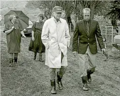  ??  ?? Strolling in the rain at the Walton farm in Aokautere, Rosalynn Carter with an umbrella, left rear, and Jimmy Carter, front left.