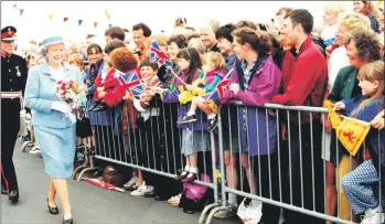  ?? 01_B31twe07 ?? The Queen is adored by the crowds gathered at the pier.