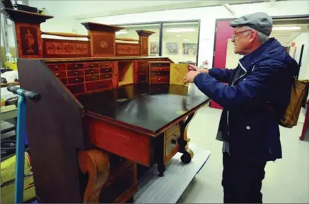  ?? DAVID BEBEE, RECORD STAFF ?? Richard Fuller, conservato­r at the Waterloo Region Museum, shows how a secret compartmen­t in a handcrafte­d antique desk works.