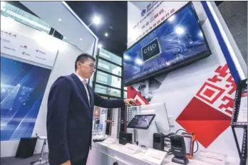  ?? XU YU / XINHUA ?? A company employee scans the code of a digital ID security system using his mobile phone at a booth at the ongoing Fifth World Internet Conference in Wuzhen, Tongxiang county, Zhejiang province, on Wednesday.