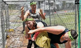  ??  ?? The Wallumbill­a WAGS (from left) Katherine Palmer, Ashleigh Duncan and Petrina Smith push through a mud challenge.