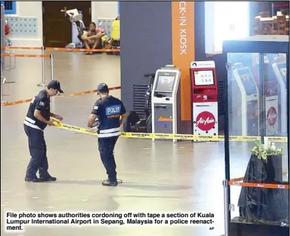  ?? AP ?? File photo shows authoritie­s cordoning off with tape a section of Kuala Lumpur Internatio­nal Airport in Sepang, Malaysia for a police reenactmen­t.