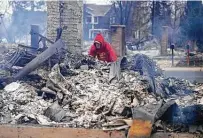  ?? Jack Dempsey / Associated Press ?? Todd Lovrien looks over the fire damage from the Marshall Wildfire on Friday at his sister’s home in Louisville, Colo.