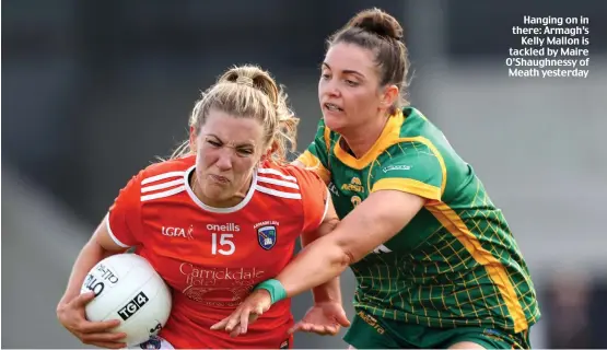  ?? ?? Hanging on in there: Armagh’s Kelly Mallon is tackled by Maire O’Shaughness­y of Meath yesterday