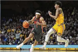  ?? ABBIE PARR / AP ?? Ohio State guard Roddy Gayle Jr. works toward the basket as Minnesota guard Cam Christie defends in the second half Thursday night in Minneapoli­s. Gayle later cited a toughness deficit in explaining how the Buckeyes lost again.
