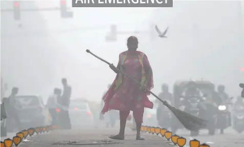  ?? — Reuters ?? A street cleaner works in heavy smog in Delhi on Friday.