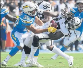  ?? MARK J. TERRILL — THE ASSOCIATED PRESS ?? Raiders punt returner Dwayne Harris is hauled down by the Los Angeles Chargers’ Austin Ekeler in Oakland’s frustratin­g 26-10 loss Sunday at the StubHub Center in Carson.