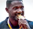  ?? AFP ?? Gatlin poses on the podium with the 100m gold medal. —