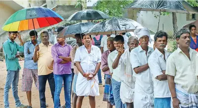  ??  ?? (Clockwise from top) Voters queue up with umbrellas in a polling station during rain, an elderly woman being assisted to reach the polling station at Vikravandi, people awaiting their turn to vote in a booth at Nanguneri and women at a booth in Vikravandi on Monday