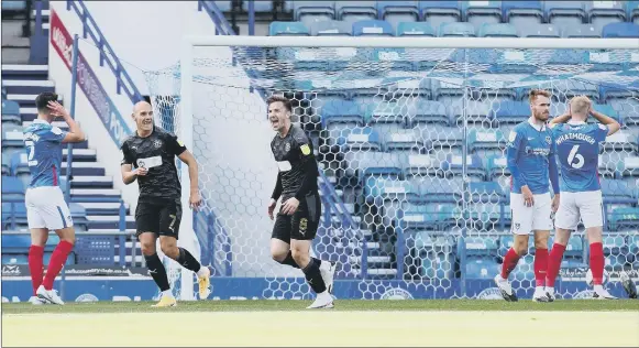  ?? Pictures: PinPeP ?? FALLING BEHIND Pompey’s frustratio­n is evident as Wigan Athletic celebrate after opening the scoring in their 2-1 victory at Fratton Park on Saturday.