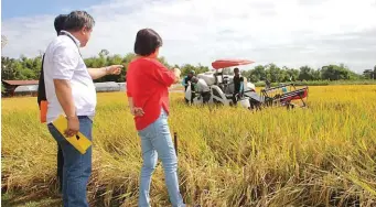  ??  ?? Jallorina discusses the advantages of a combine harvester to Senator Villar in enhancing farm productivi­ty and efficiency.