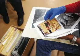  ?? Jon Shapley / Staff photograph­er ?? Miguell Ceasar, manager of the archives, looks at photos from former Houston Chronicle photojourn­alist Ben Tecumseh DeSoto.