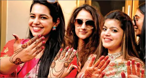  ?? IANS ?? Women show their ‘mehndi’ on the eve of Karva Chauth in Amritsar on Friday.
