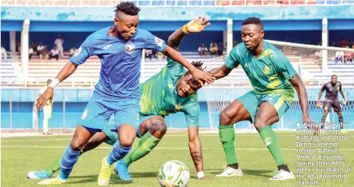  ??  ?? Kano Pillars duo of Ndasi Dennis Kadiang and VIctor Dennis attempt to stop Gabriel Orok of Enyimba during their NPFL week four match at the Aba Township stadium