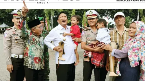  ?? CHUSNUL CAHYADI/JAWA POS ?? BERSAMA ORANG TUA KORBAN: Bupati Sambari dan AKBP Didik Hariyanto menggendon­g Danish dan Naufal sambil membawa kaki palsu di halaman Kantor Pemkab Gresik kemarin.